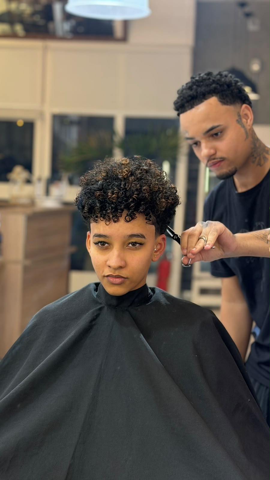 Marco finalizando corte em cabelo crespo